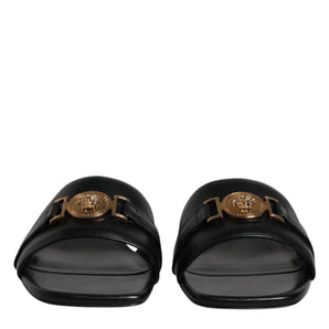 Sandalias planas sin cordones con placa del logotipo de cuero negro de Versace